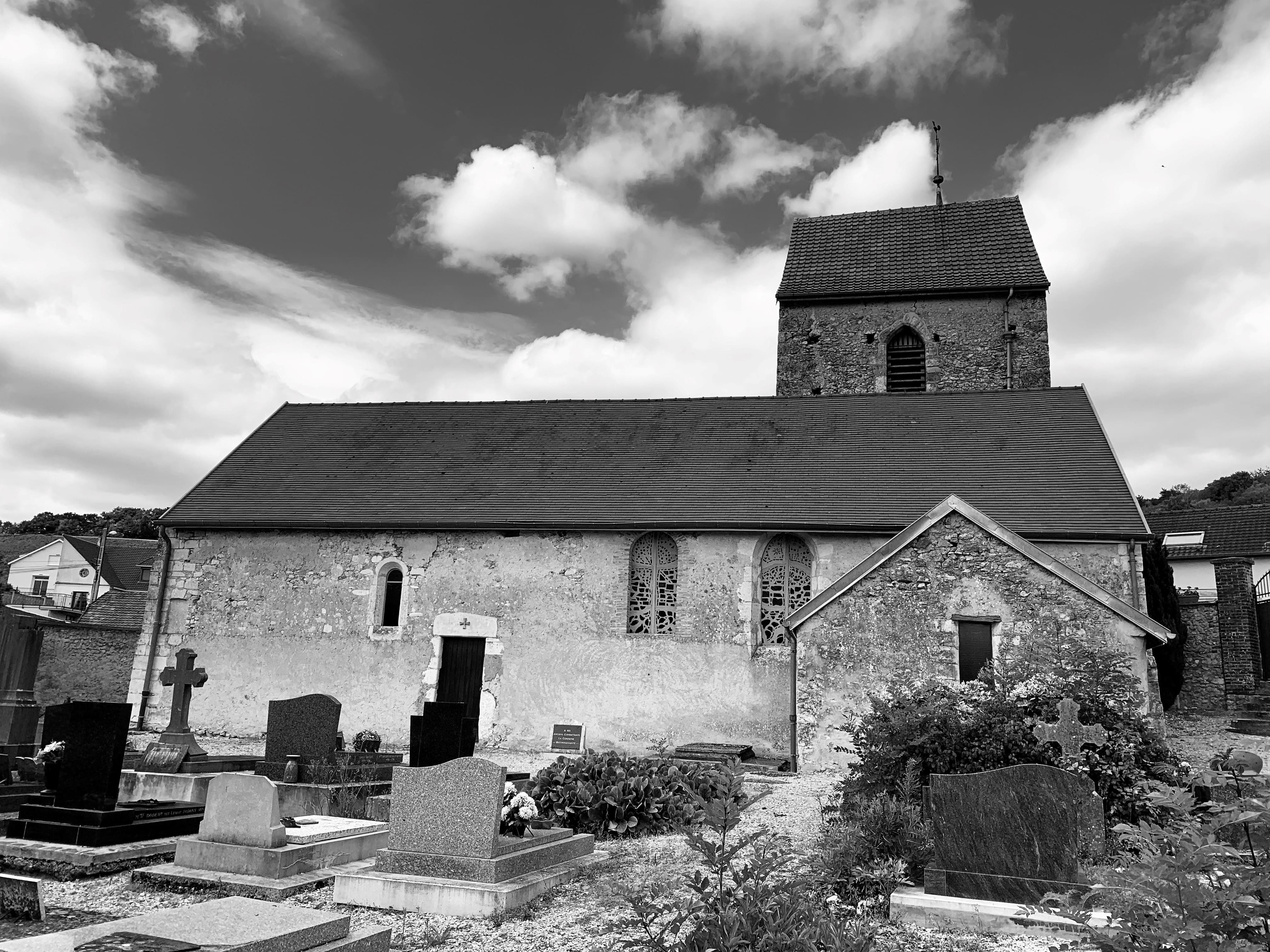 Vue d'ensemble de l'église Saint-Clément avec son clocher et le cimetière